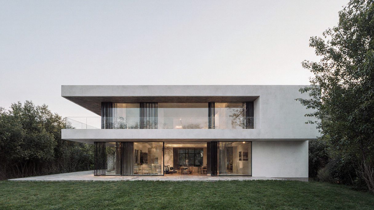 A concrete house with a deep flat roof, its whole ground floor sliding open onto a lawn